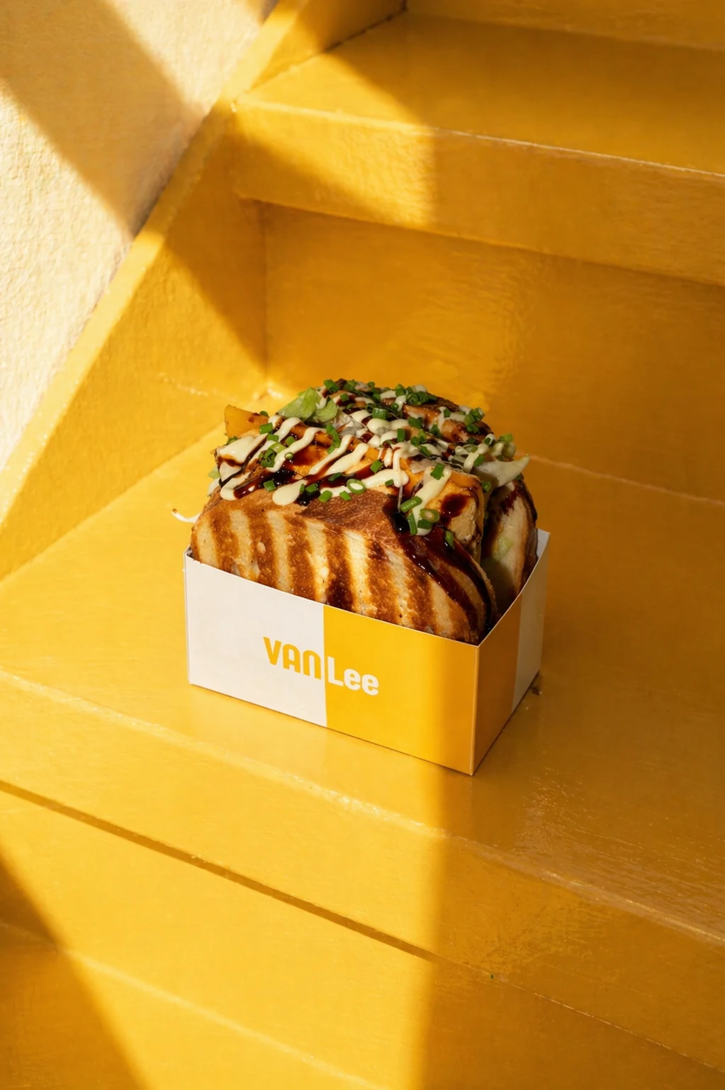 Eggdrop Sandwich auf gelber Treppe im Sonnenlicht